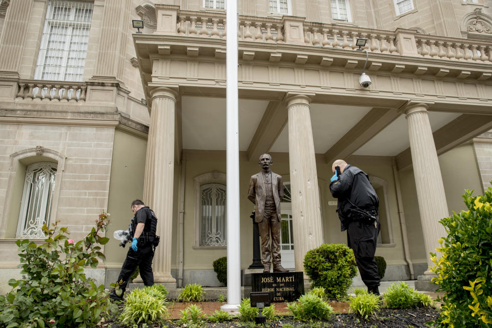 Bullet holes are visible on a column behind a statue of Cuban independence hero José Martí as Secret Service officers investigate after police say a person with an assault rifle opened fire at the Cuban Embassy, Thursday, April 30, 2020, in Washington. Officers found the suspect with an assault rifle and took the person into custody without incident, police said. (AP Photo/Andrew Harnik)