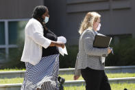 Carolyn Johnson, left, exits the Thad Cochran United States Courthouse in Jackson, Miss., Thursday, Aug. 6, 2020, accompanied by attorney Bethany Johnson, after being arraigned in federal court on immigration crimes and other federal charges stemming from the largest single-state worksite enforcement action last year at a number of Mississippi poultry processing plants. (AP Photo/Rogelio V. Solis)