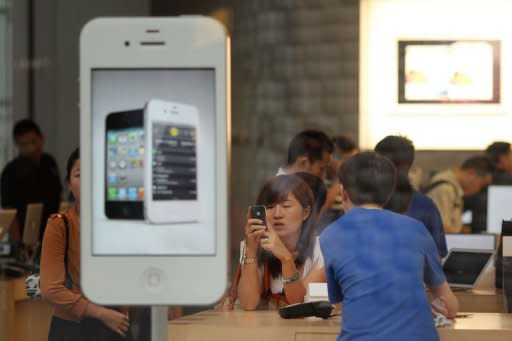 Customers looking at products in an Apple store in Beijing. A labour rights group said June 28, it had found "deplorable" conditions at Apple suppliers in China, following a probe of several firms that supply the US technology giant