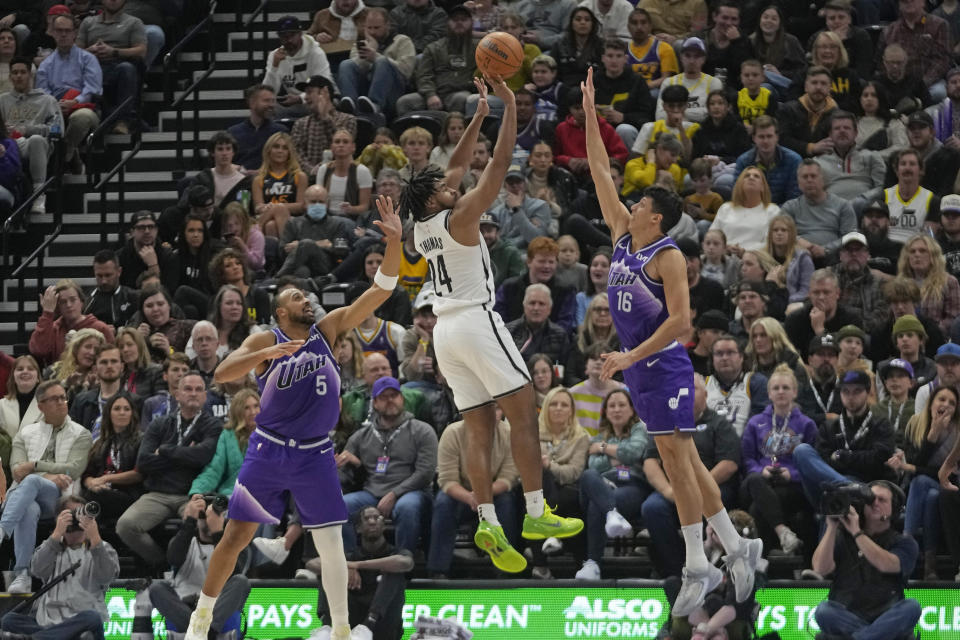 Brooklyn Nets guard Cam Thomas (24) shoots as Utah Jazz's Talen Horton-Tucker (5) and Simone Fontecchio (16) defend during the first half of an NBA basketball game Monday, Dec. 18, 2023, in Salt Lake City. (AP Photo/Rick Bowmer)