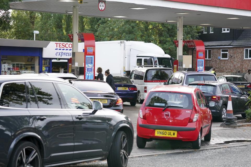 Drivers queue for fuel at a petrol station in Birmingham, England, Tuesday, Sept. 28, 2021. Long lines of vehicles have formed at many gas stations around Britain since Friday, causing spillover traffic jams on busy roads. (AP Photo/Jacob King)