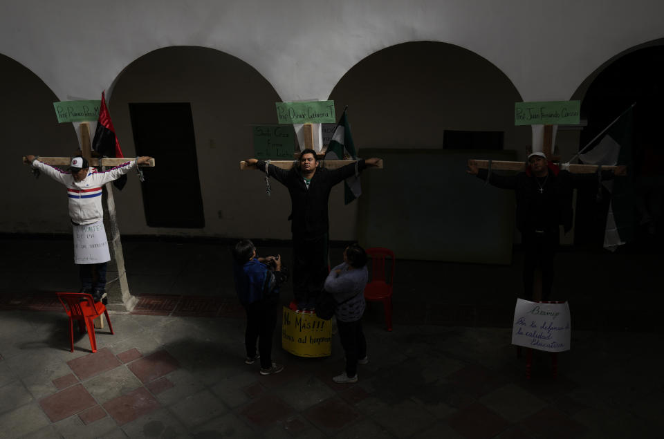Los educadores se crucifican simbólicamente al margen de la marcha del Día del Trabajo en La Paz, Bolivia, el lunes 1 de mayo de 2023. Los maestros exigen salarios más altos y protestan por el nuevo plan de estudios impuesto por el gobierno. (AP Foto/Juan Karita)