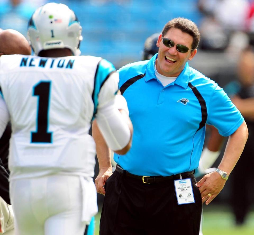 (R-L) Carolina Panthers head coach Ron Rivera smiles at quarterback Cam Newton (1) as the team begins drills prior to action vs the Jacksonville Jaguars Sunday, September 25, 2011 at Bank of America Stadium in Charlotte, NC. Jeff Siner - jsiner@charlotteobserver.com