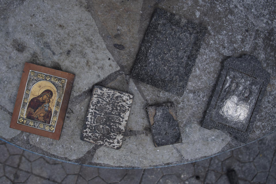 Burned holy icons are seen in Acharnes suburb, on Mount Parnitha, in northwestern Athens, Greece, Sunday, Aug. 27, 2023. More than 600 firefighters, including reinforcements from several European countries, backed by a fleet of water-dropping planes and helicopters were battling three persistent major wildfires in Greece Sunday, two of which have been raging for days. (AP Photo/Michael Varaklas)