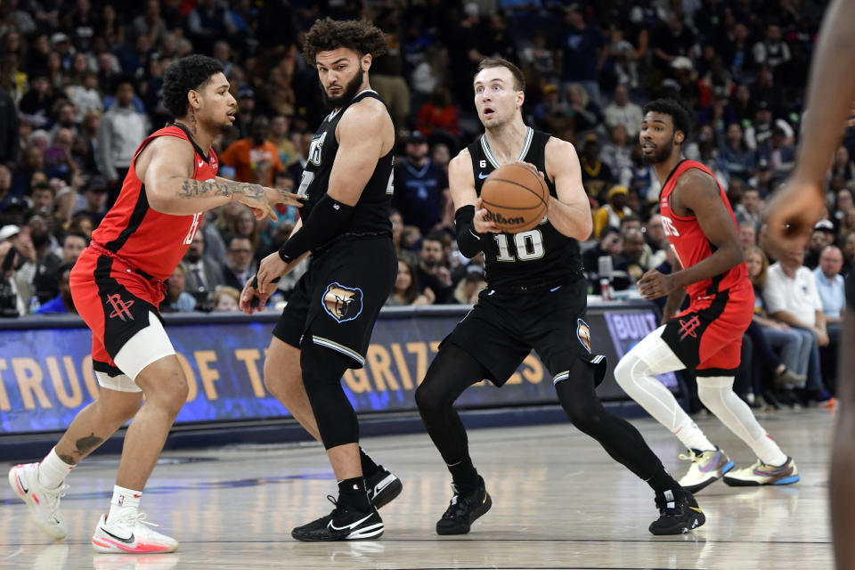 Memphis Grizzlies guard Luke Kennard (10) looks to take a 3-point shot as Grizzlies forward David Roddy, second from left, and Houston Rockets guard Daishen Nix (15) move for position in the second half of an NBA basketball game Friday, March 24, 2023, in Memphis, Tenn. (AP Photo/Brandon Dill)