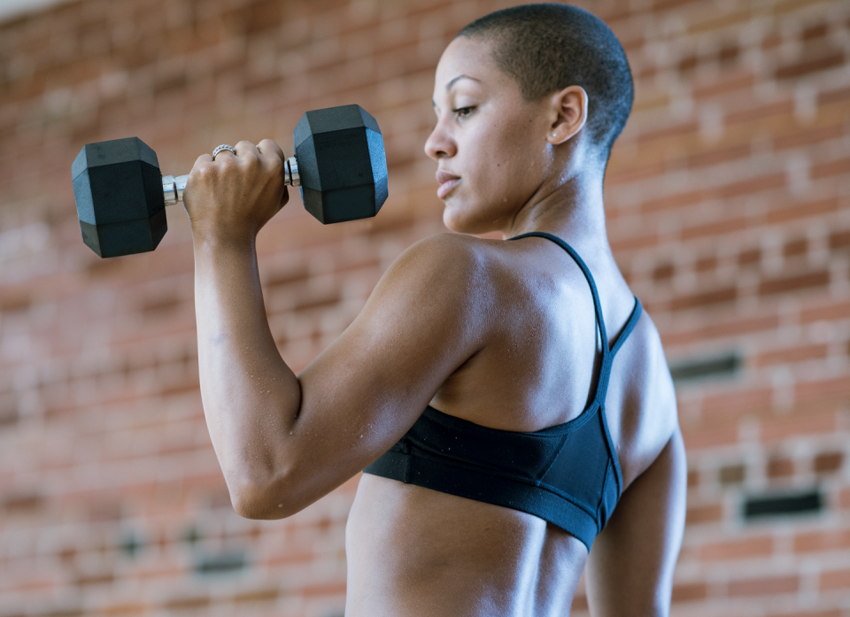 woman lifting dumbbells in a bicep curl