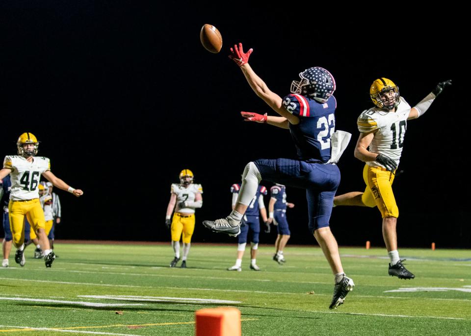 Central Bucks East tight end Jack Donnelly reaches for a pass tipped by Central Bucks West middle linebacker Cooper Taylor in a football game at Patriots Stadium in Buckingham, on Friday, October 28, 2022. The Bucks defeated the Patriots 21-14.