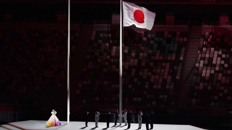 <div class="paragraphs"><p>Officials unfurl the Japanese national flag at the National Stadium on Friday</p></div>