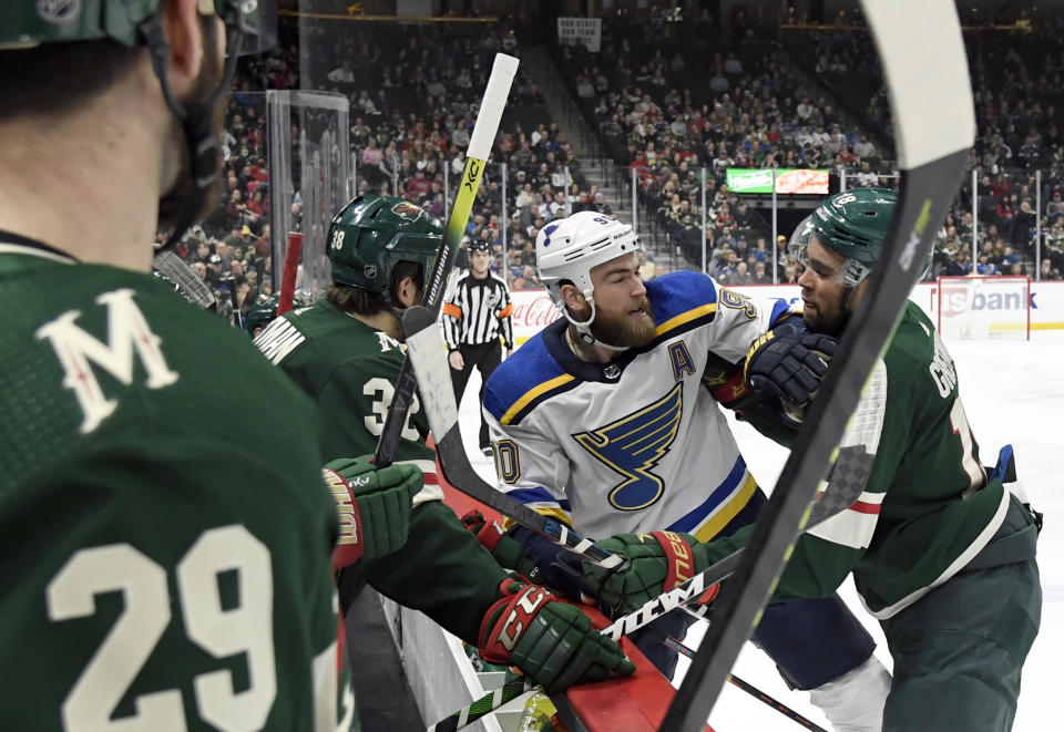 St. Louis Blues' Ryan O'Reilly (90) and Minnesota Wild's Jordan Greenway (18) shove each other in front of the Minnesota Wild bench after a whistle during the second period of an NHL hockey game Sunday, Feb. 23, 2020, in St. Paul, Minn. (AP Photo/Hannah Foslien)