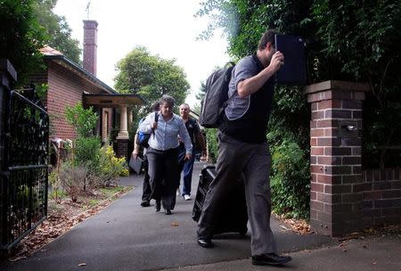 Officers from the Australian Government Tax Department, along with Australian Federal Police, walk down the driveway after searching the rented home of probable creator of cryptocurrency bitcoin Craig Wright in Sydney's north shore, Australia, December 9, 2015. REUTERS/David Gray/File photo