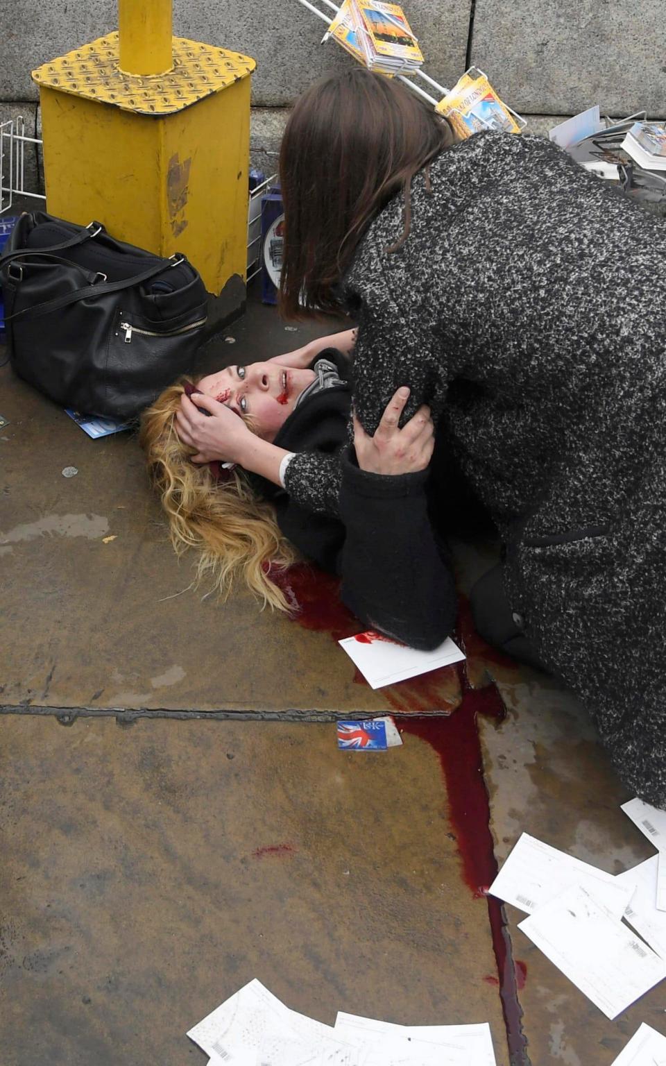 An injured woman is assisted after an incident on Westminster Bridge in London