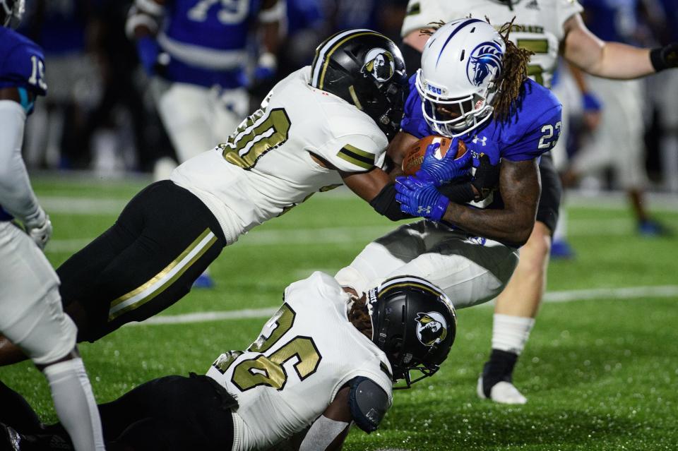 Fayetteville's Elijah Henry gets hit by Pembroke's B.J. Tobe and D'Andre Ferguson during the second quarter on Saturday, Sept. 3, 2022, at Fayetteville State University.