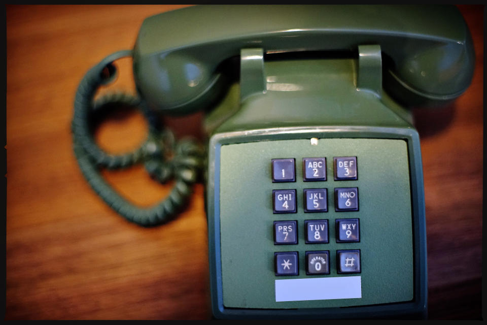 Vintage push-button telephone on a wooden surface