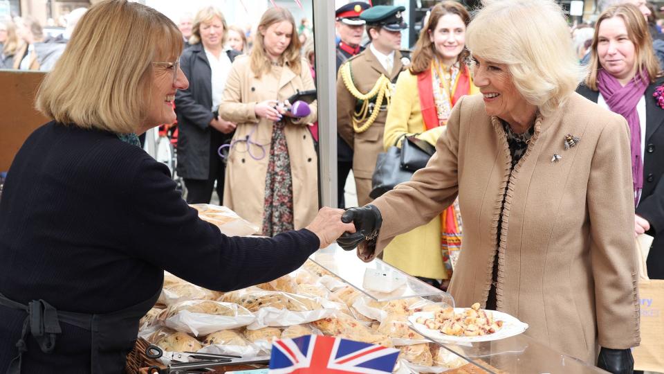 Queen Camilla shakes hands with a market trader during her visit to the Farmers' Market on March 27, 2024 in Shrewsbury, England. 