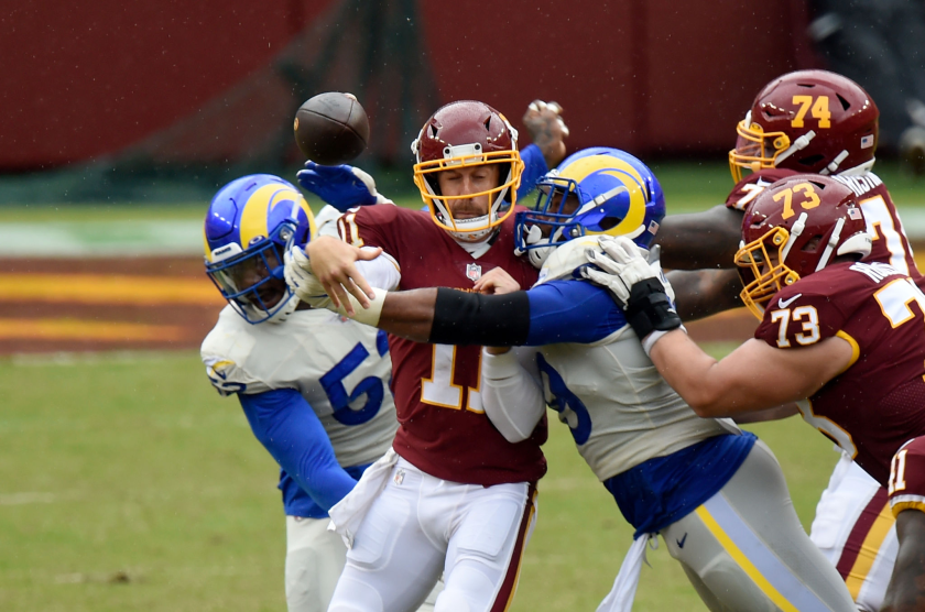 LANDOVER, MD - OCTOBER 11: Alex Smith #11 of the Washington Football Team is hit by Aaron Donald.