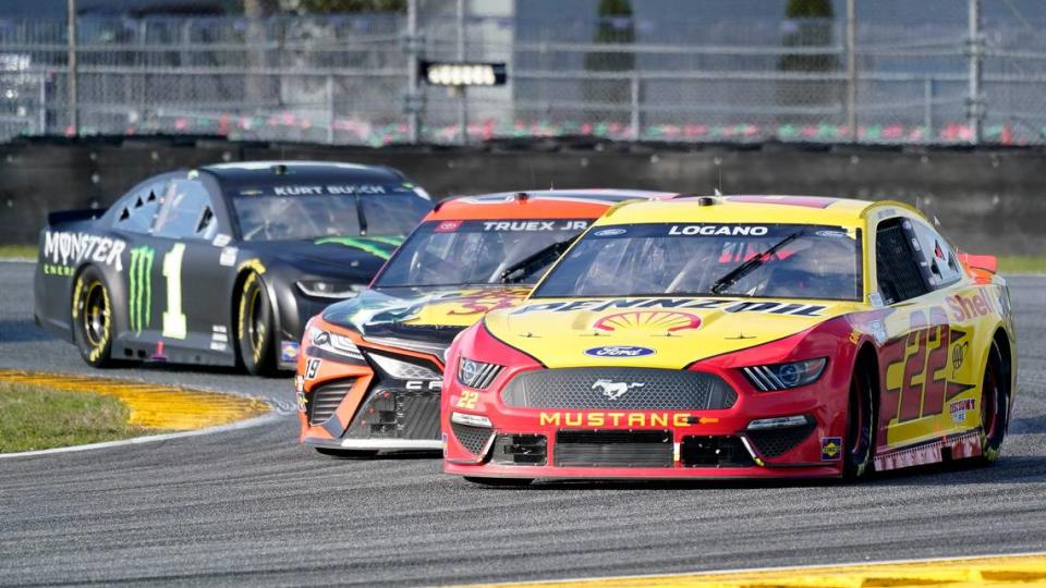 Joey Logano (22) leads Martin Truex Jr., center, and Kurt Busch (1) through a horseshoe turn in the NASCAR Cup Series road course auto race at Daytona International Speedway, Sunday, Feb. 21, 2021, in Daytona Beach, Fla. (AP Photo/John Raoux)