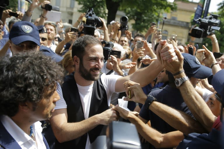 Newly signed Gonzalo Higuain greets supporters near the Juventus' headquarter in Turin, on July 27, 2016