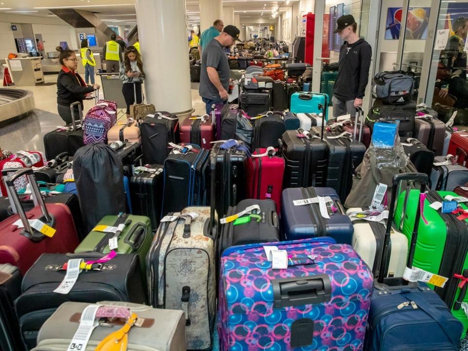 Southwest Airlines passengers stand around dozens of bags during the carrier's December 2022 meltdown.
