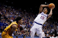 Kansas guard Kevin McCullar Jr. (15) shoots over Iowa State guard Tamin Lipsey during the first half of an NCAA college basketball game Saturday, Jan. 14, 2023, in Lawrence, Kan. (AP Photo/Charlie Riedel)