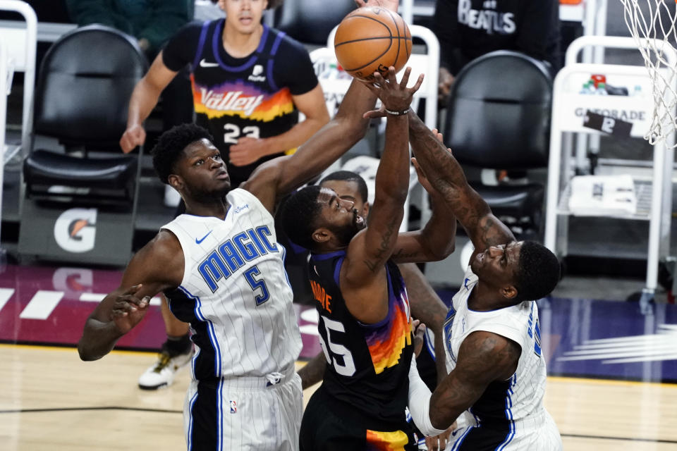 Phoenix Suns guard E'Twaun Moore (55) drives past Orlando Magic center Khem Birch and center Mo Bamba (5) during the first half of an NBA basketball game Sunday, Feb. 14, 2021, in Phoenix. (AP Photo/Rick Scuteri)