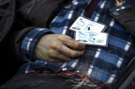 Identification cards on a man as policemen work on the indentification process following the killing of civilians in Bucha, before sending the bodies to the morgue, on the outskirts of Kyiv, Ukraine, Wednesday, April 6, 2022. (AP Photo/Rodrigo Abd)