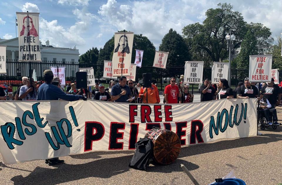 PHOTO: Dallas Goldtooth, Indigenous activist and actor, speaks behind a banner that reads 'Free Peltier.' (Mahika Gupta/ABC News)