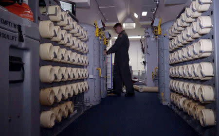 A member of the U.S. Navy, aboard the Boeing P-8A Poseidon plane, places a sonobuoy in the launching compartment to drop it at sea as they fly over the South Atlantic Ocean during the search for the ARA San Juan submarine missing at sea, Argentina November 22, 2017. A sonobuoy is an expendable sonar system that is ejected from aircraft or ships conducting anti-submarine warfare or underwater acoustic research. Picture taken November 22, 2017. REUTERS/Magali Cervantes