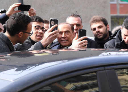 Forza Italia party leader Silvio Berlusconi poses for a selfie after casting his vote at a polling station in Milan, Italy March 4, 2018. REUTERS/Alberto Lingria