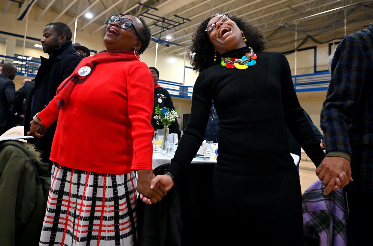 Sandra Alafberg, left, and her daughter, Ashley Wonder, both members of the Covenant United Methodist Church of Worcester, join in singing "We Shall Overcome" at the conclusion of the 39th Annual Martin Luther King Jr. Community Breakfast Monday at Assumption University honoring Martin Luther King Jr..