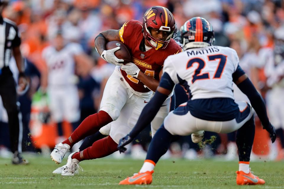 Sep 17, 2023; Denver, Colorado, USA; Washington Commanders running back Antonio Gibson (24) runs the ball as Denver Broncos cornerback Damarri Mathis (27) defends in the fourth quarter at Empower Field at Mile High. Mandatory Credit: Isaiah J. Downing-USA TODAY Sports