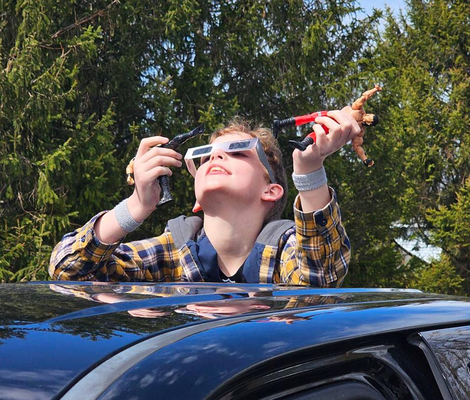 Brantley Eicher, 9, of Altoona gazes at the sun from the bed of his grandfather's pickup truck on April 8, 2024 to view the total solar eclipse in North East.