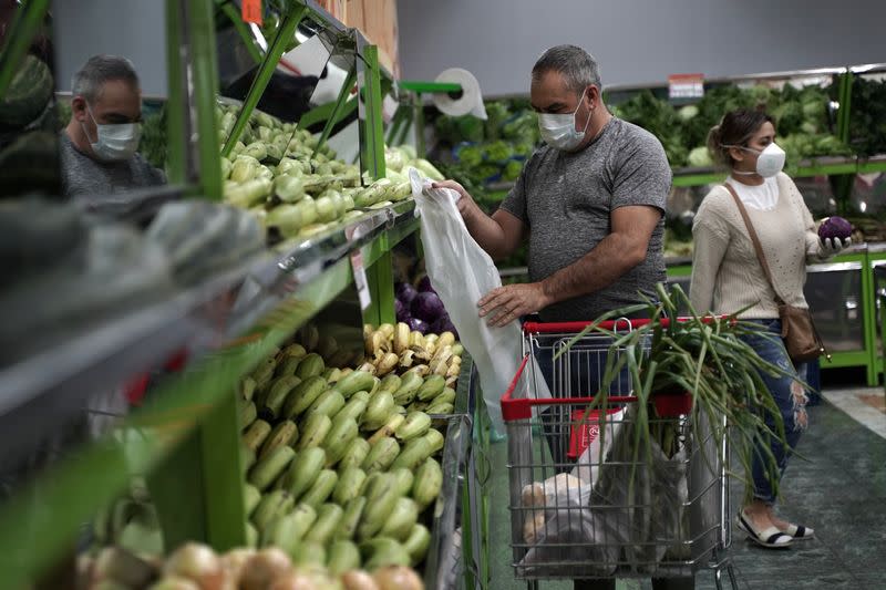 Personas usando tapabocas compran alimentos, antes del comienzo del aislamiento obligatorio de 19 días decretado por el Gobierno como medida preventiva contra la propagación del coronavirus, en un supermercado de Bogotá