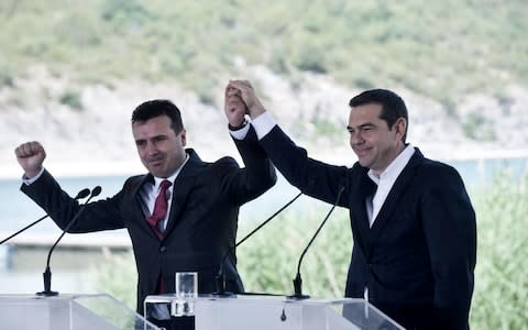 Alexis Tsipras, right, and Macedonian Prime Minister Zoran Zaev raise their hands during the signing ceremony  - Credit: SAKIS MITROLIDIS/ AFP