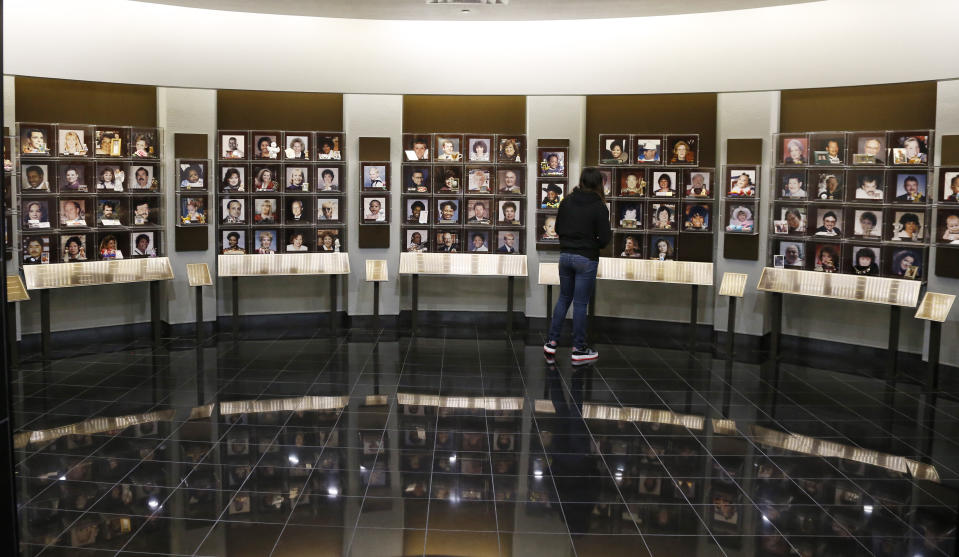 In this April 17, 2014 photo a visitor walks through a renovated Gallery of Honor, an exhibit about victims of the bombing, that is part of the $7 million upgrade at The Oklahoma City National Memorial & Museum, in Oklahoma City. (AP Photo/Sue Ogrocki)