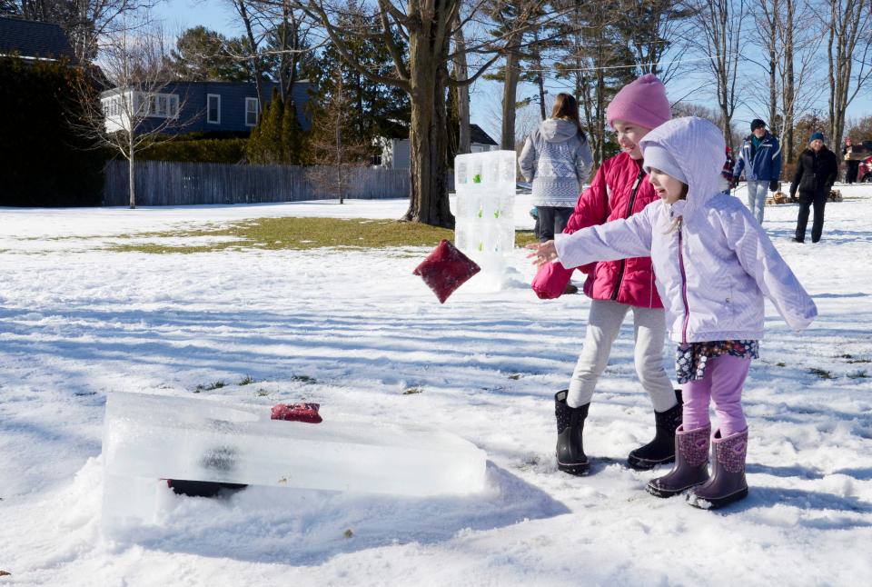 Eliza (front) and Adalynn Trahin from Wolverine play an icy version of cornhole on Saturday, Feb. 11, 2023 during the Harbor Springs Ice Fest.