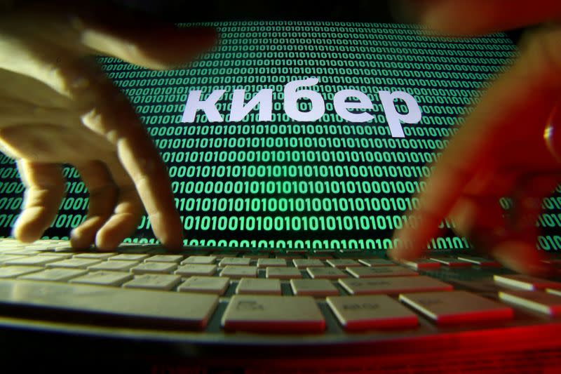 FILE PHOTO: Hands are seen on a keyboard in front of a displayed cyber code in this picture illustration