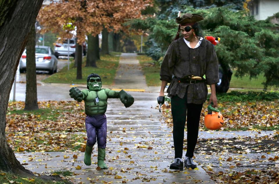 W-HALLOWEEN, NWS, PORTER, 06 - Kevin , right and his son Makaden Green Trick or Treat on W. Washington Blvd. during Milwaukee's Trick-or-Treating this year on Halloween. October 31, 2015. Gary Porter for the Journal Sentinel.