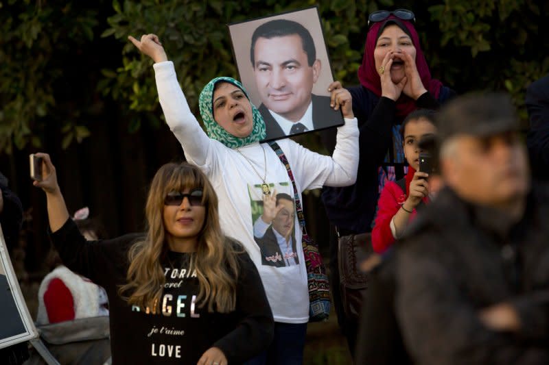 少數穆巴拉克的支持者在法院外高舉其照片。（美聯社）