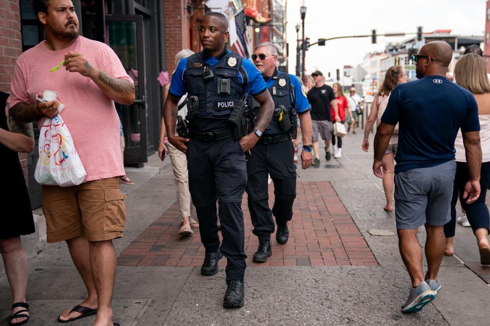 Metro Nashville Police Sgt. Devonte Coleman, front, and Lt. Paul Stein, rear, of the Entertainment District Unit walk along Lower Broadway in Nashville on July 13. Entertainment District Unit officers work Thursday through Sunday nights patrolling Lower Broadway, the Gulch, and neighboring areas.