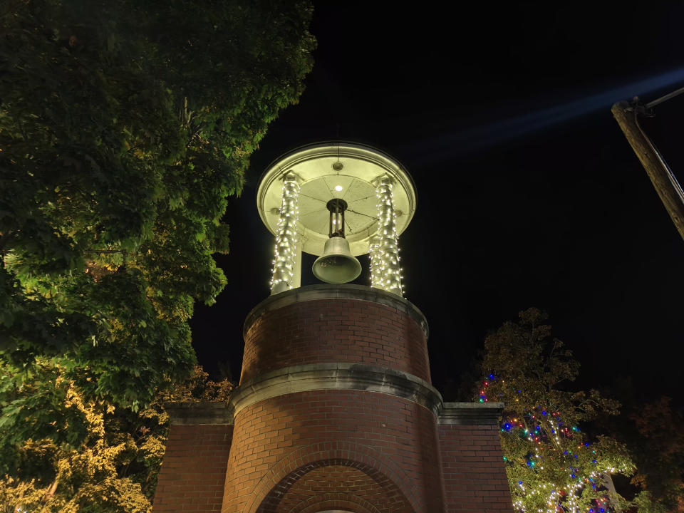 A bell tower at night with lights