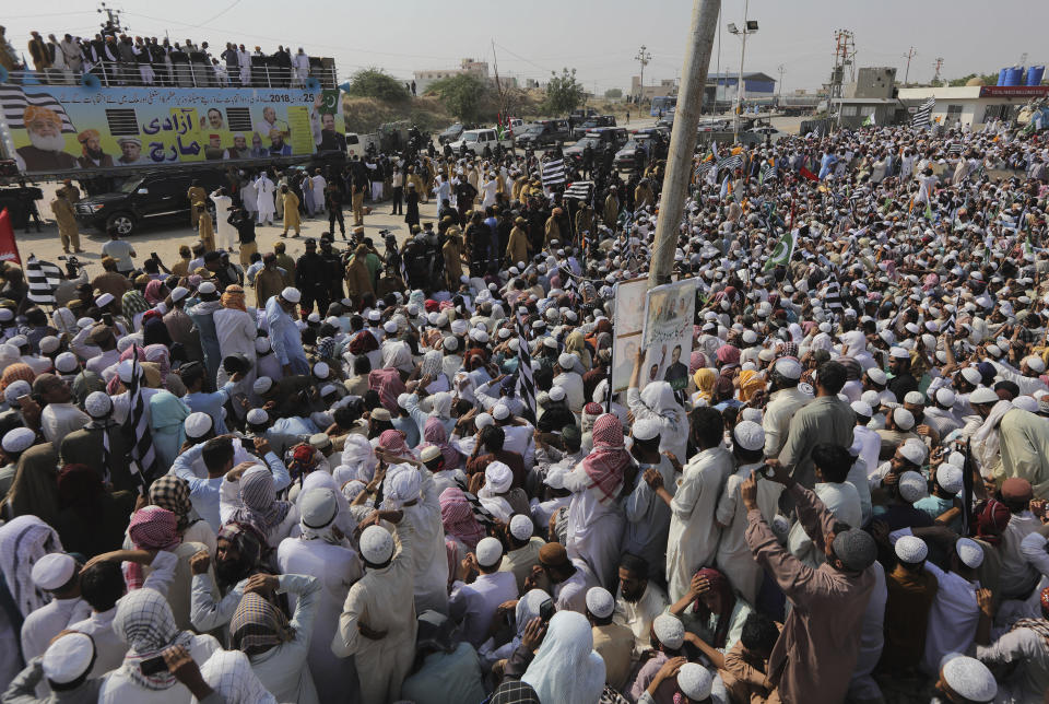 Supporters of the Jamiat Ulema-e-Islam party listen a speech by their leader while they gather to start an anti-government march, in Karachi, Pakistan, Sunday, Oct. 27, 2019. Thousands of supporters of the ultra-religious party are gathering in Karachi to start a large anti-government march on Pakistan's capital farther north. (AP Photo/Fareed Khan)