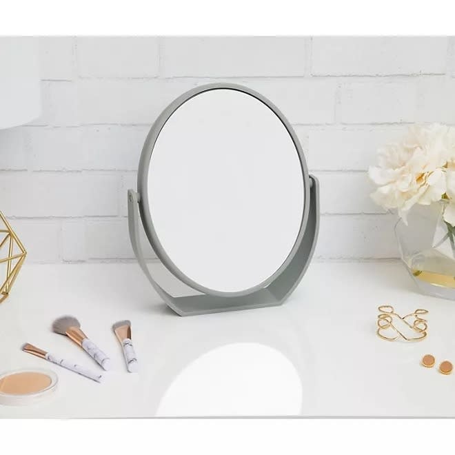 small gray oval-shaped vanity mirror