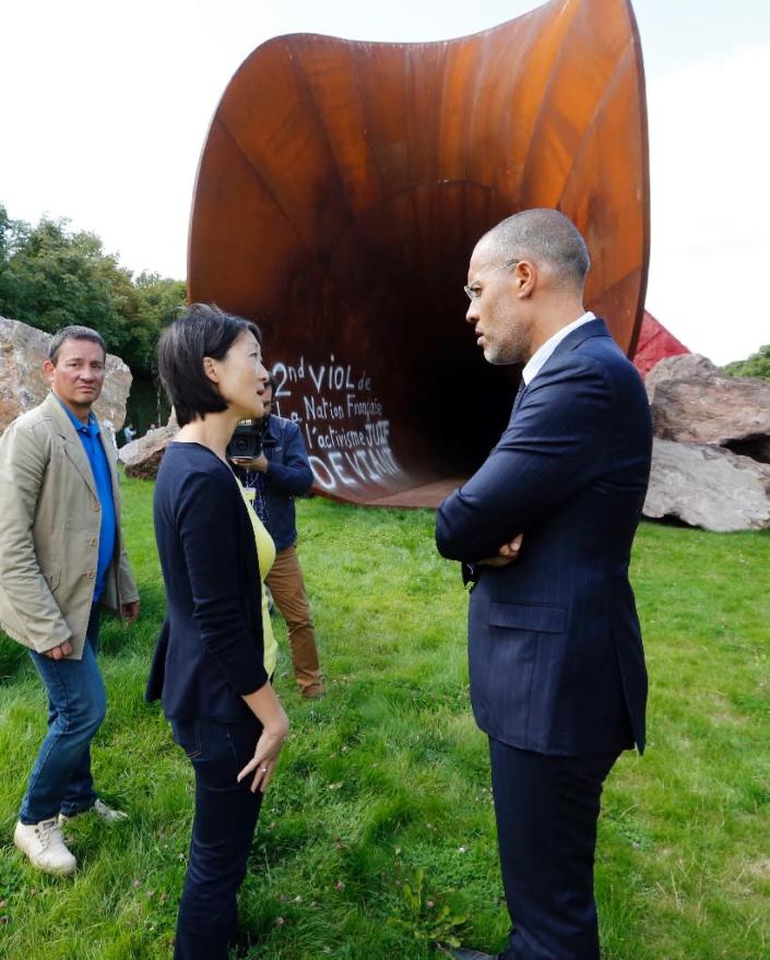 French Minister of Culture Fleur Pellerin (C) speaks with Gallery-owner Kamel Mennour (R) before "Dirty Corner", a 2011 Cor-Ten steel, earth and mixed media monumental artwork by Anish Kapoor, vandalized on September 6, 2015 in Versailles (AFP Photo/Francois Guillot)