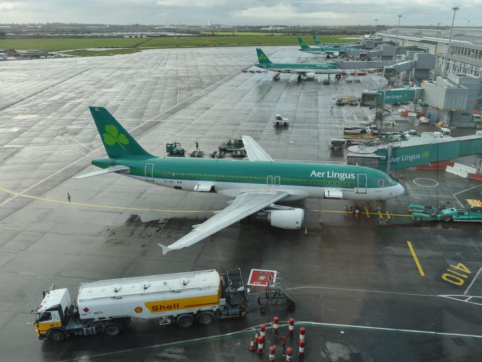 An Aer Lingus plane in Ireland's Dublin Airport. The aircraft is painted dark green and white, with a three-leaf clover on the tail.