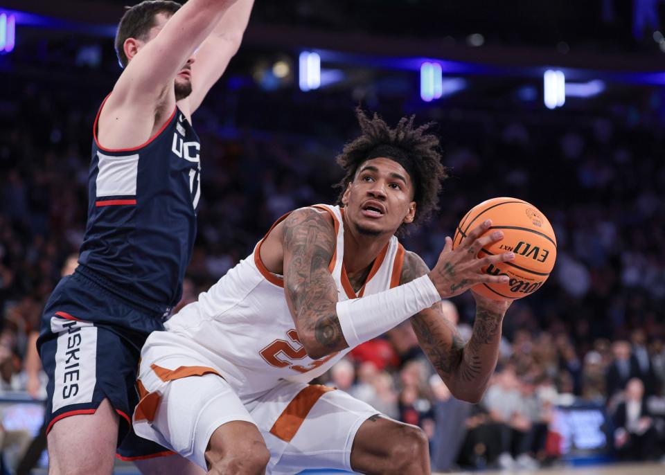 Texas forward Dillon Mitchell, right, drives to the basket against Connecticut Huskies forward Alex Karaban during the second half of the Empire Classic championship game Nov. 20 at Madison Square Garden. Connecticut, which beat Purdue in Monday's national championship game, topped Texas 81-71 in the nonconference matchup.