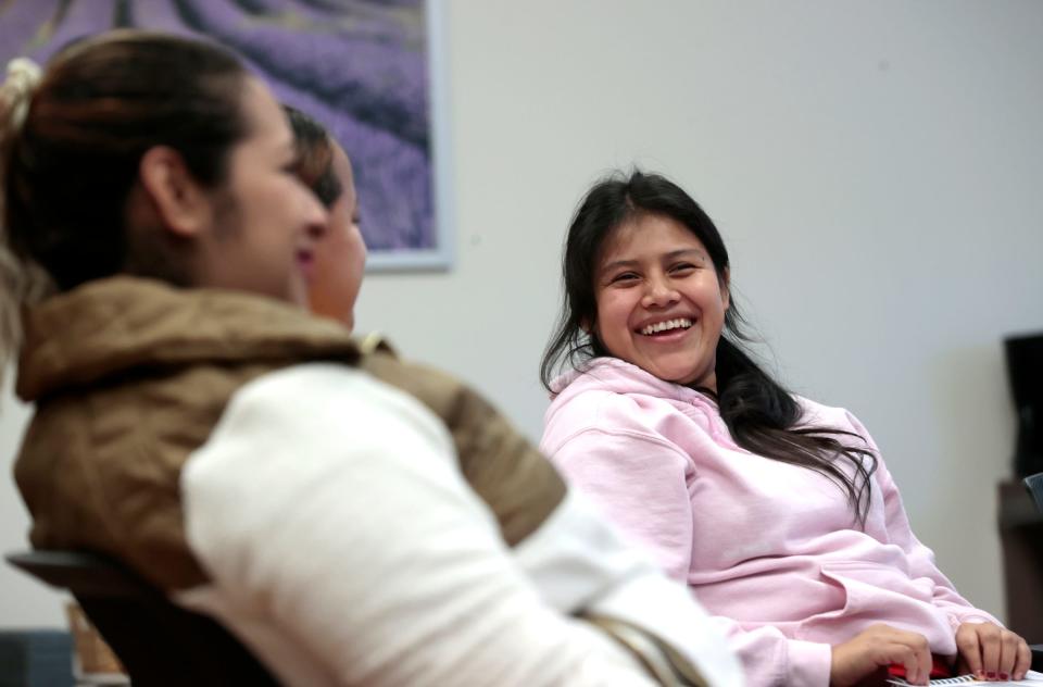 Theresa Perez, 21, of Detroit, laughs with other women in their second trimester while getting to know each other during Covenant Community Care's Centering Pregnancy program in Detroit on Oct. 11, 2023. Centering Pregnancy offers private prenatal care and group learning on the importance of relaxation during pregnancy, and prenatal yoga exercise routines that can be done at home, among other things.