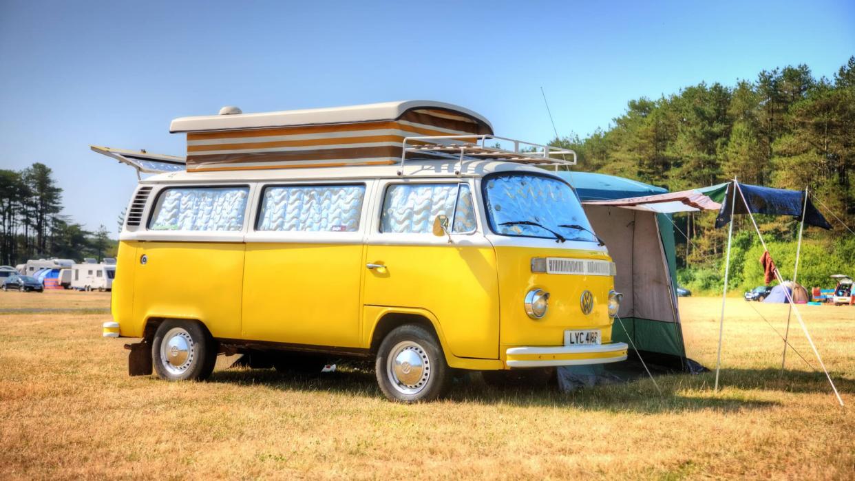 Pembrey, Wales - July 13, 2013: Old fashioned VW campervan on Welsh campsite with canvas awning attached.