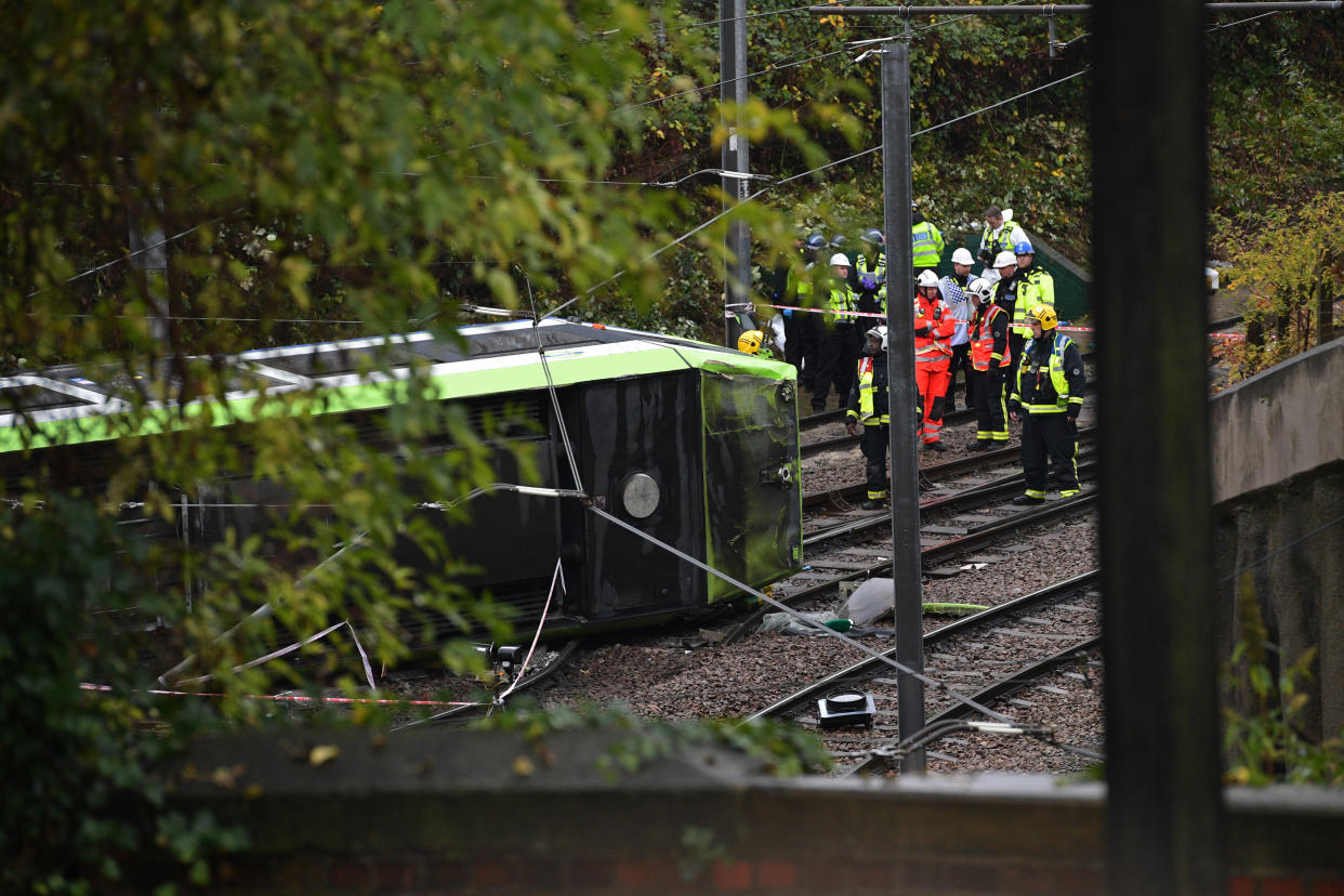 LONDON, ENGLAND - NOVEMBER 09: Members of London Fire Brigade look at the overturned tram at the site near Sandilands Tram stop in Croydon on November 9, 2016 in London, England. Five people are trapped after a tram derailed in a tunnel near Sandilands Tram stop in Croydon at 6.04am this morning. A further 50 people have been injured. (Photo by Carl Court/Getty Images)