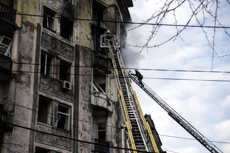 Ukrainian firefighters at the scene of a missile strike Thursday in Kyiv, Ukraine, amid the Russian invasion. The strikes damaged residential buildings and injured at least ten people. EPA-EFE/Maxym Marusenko