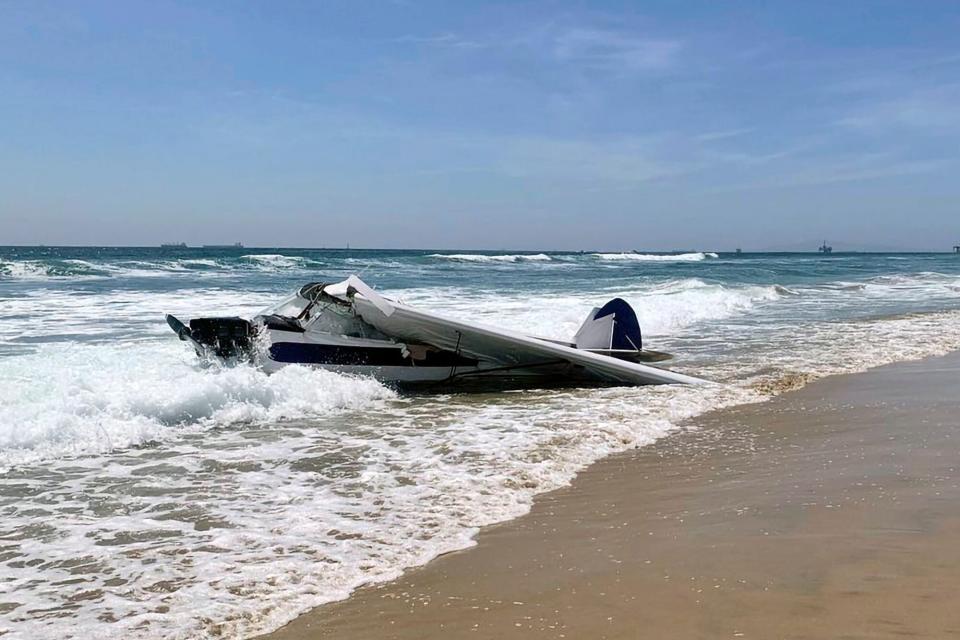 Mandatory Credit: Photo by Uncredited/AP/Shutterstock (13044451a) In this image provided by the Huntington Beach Fire Department, a small plane sits in the surf after it crashed into the ocean just off Huntington Beach, Calif.,, during a lifeguarding competition. A Coast Guard spokesperson says the plane went down Friday about 30 yards from shore and the pilot was rescued. He was the only person aboard Beach Plane Crash, Huntington Beach, United States - 22 Jul 2022